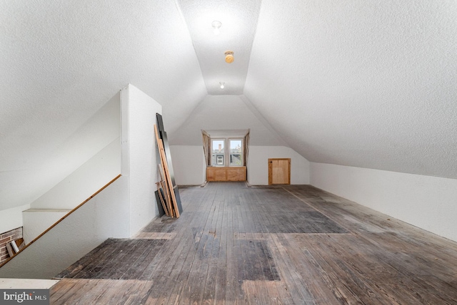 bonus room featuring hardwood / wood-style flooring, a textured ceiling, and lofted ceiling
