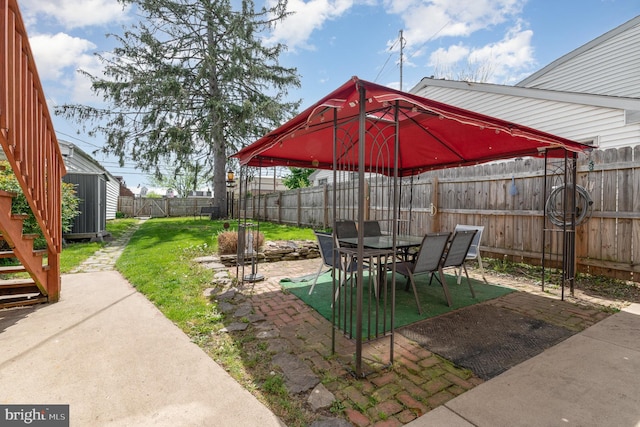 view of yard with outdoor dining space, a fenced backyard, and a patio area