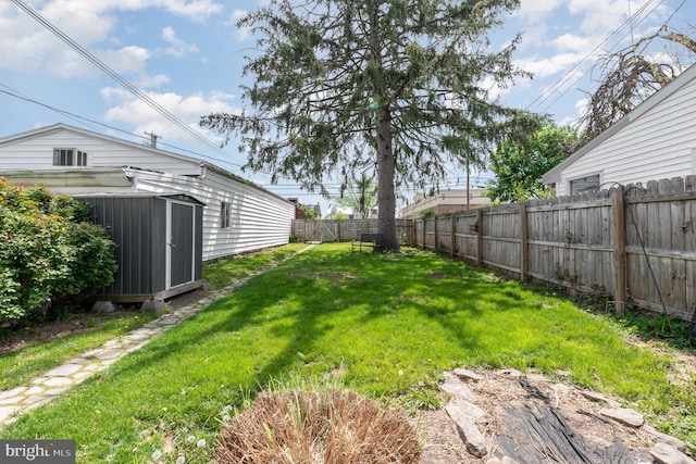 view of yard with a fenced backyard, an outbuilding, and a storage shed