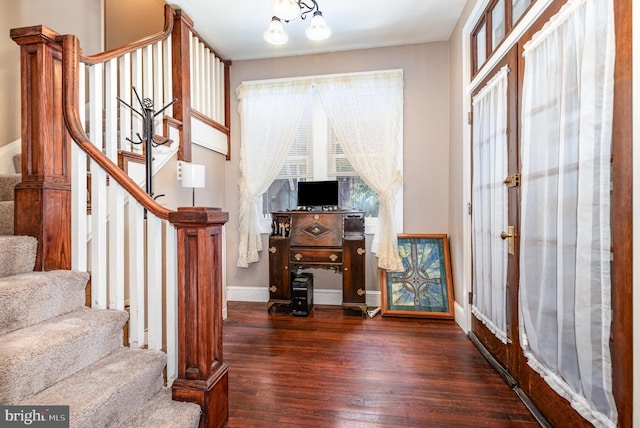 foyer entrance with wood-type flooring, baseboards, and stairs