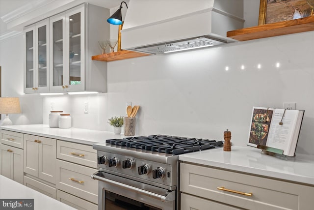 1708 10th St NW, Washington, DC 20001 - kitchen with light countertops, high end range, white cabinetry, custom exhaust hood, and glass insert cabinets