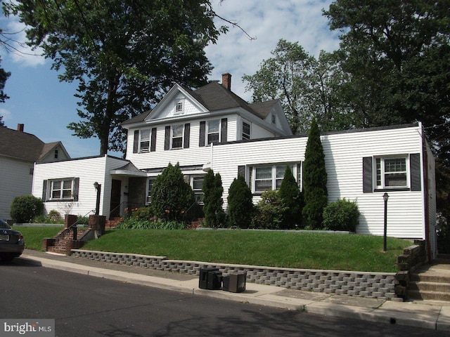 traditional-style home with a front lawn and a chimney