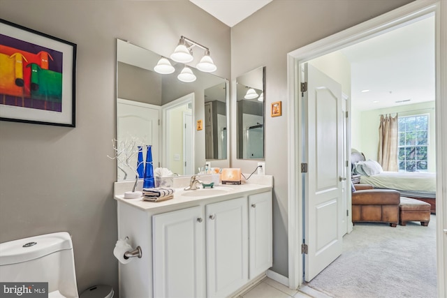 ensuite bathroom with vanity, tile patterned floors, toilet, and ensuite bath