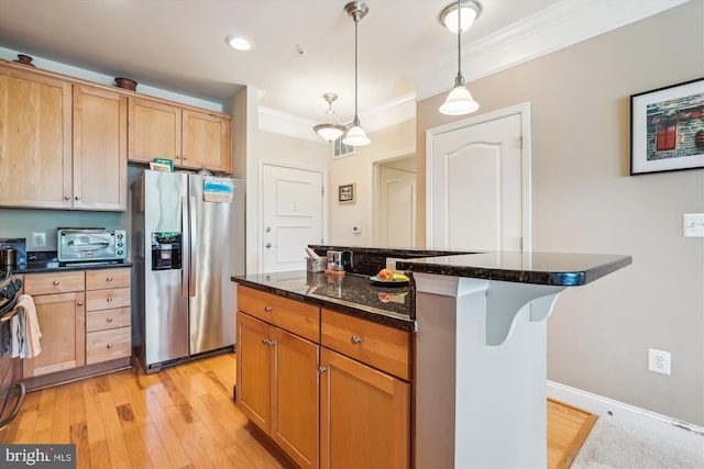 kitchen with crown molding, a breakfast bar area, stainless steel refrigerator with ice dispenser, a center island, and decorative light fixtures