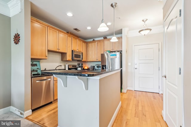 kitchen featuring baseboards, a breakfast bar area, stainless steel appliances, and visible vents