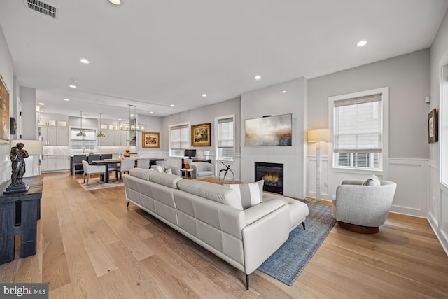 13 N Vendome Ave, Margate City, NJ 08402 - living area with light wood finished floors, a glass covered fireplace, recessed lighting, wainscoting, and a decorative wall