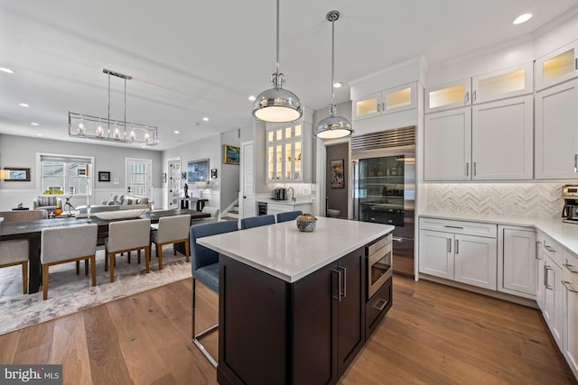 13 N Vendome Ave, Margate City, NJ 08402 - kitchen with built in appliances, open floor plan, light countertops, decorative backsplash, and wood finished floors