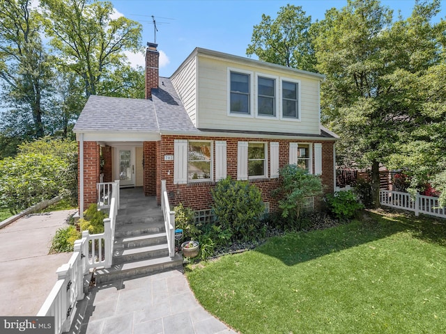 view of front of house with fence, a front yard, a porch, and brick siding