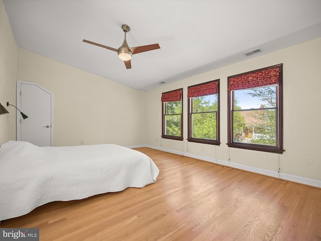 bedroom with baseboards, visible vents, multiple windows, and light wood-style flooring