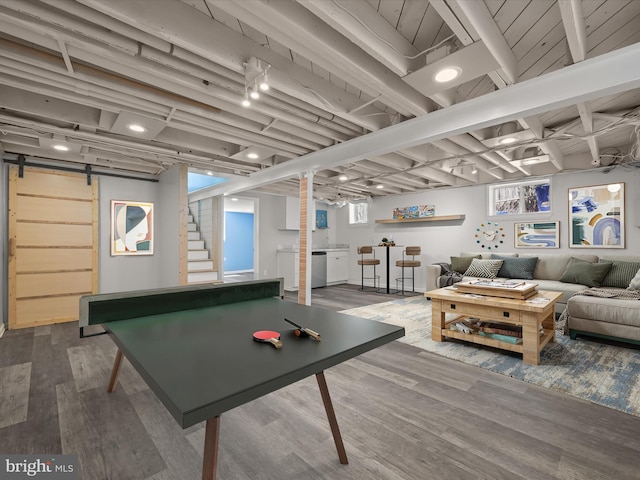 playroom featuring a barn door and wood finished floors