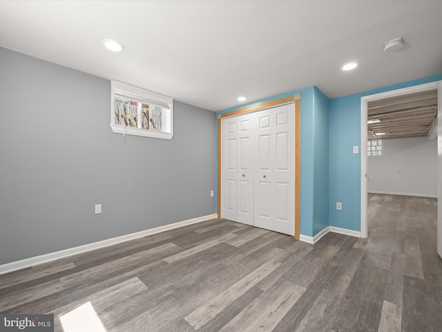 unfurnished bedroom featuring recessed lighting, baseboards, wood finished floors, and a closet