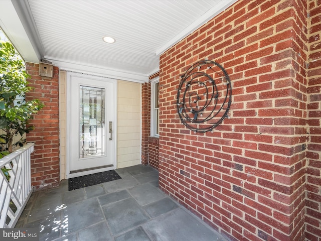 property entrance with brick siding and covered porch