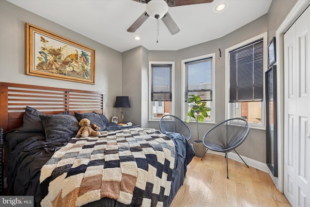 bedroom with recessed lighting, multiple windows, hardwood / wood-style flooring, and baseboards