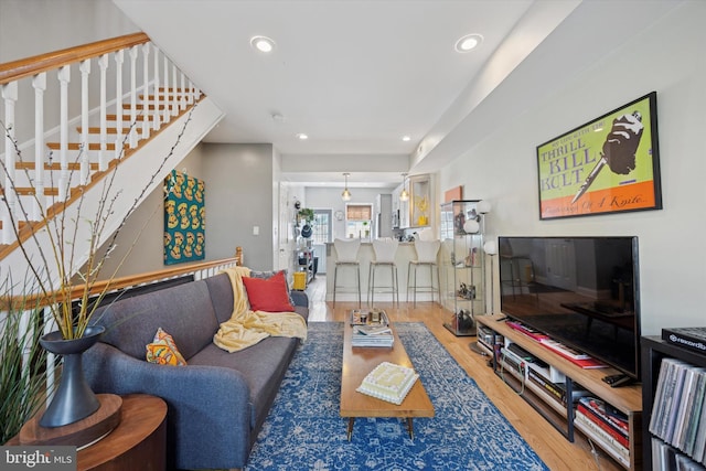 living room featuring recessed lighting, stairs, and wood finished floors