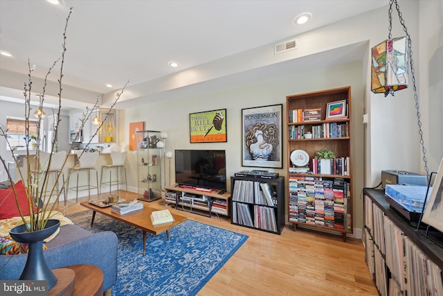 living room with wood finished floors, visible vents, and recessed lighting