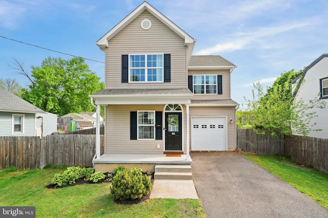traditional home with covered porch, a front yard, fence, aphalt driveway, and an attached garage