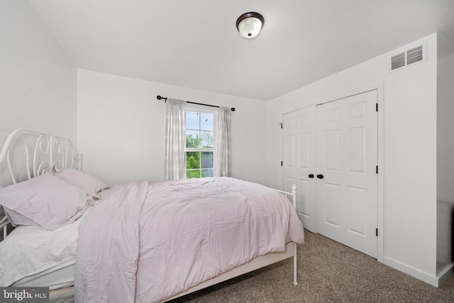 carpeted bedroom featuring baseboards, a closet, and visible vents