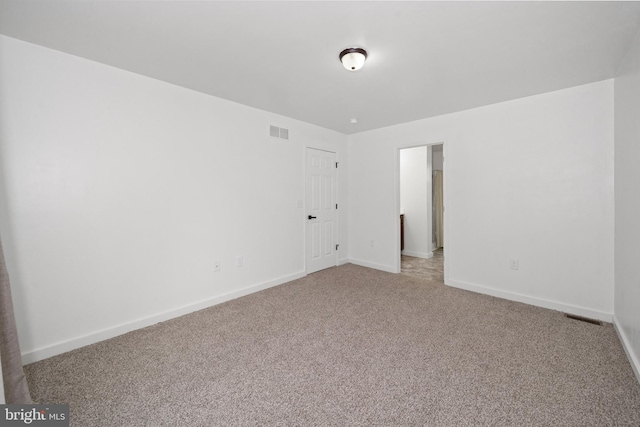 carpeted empty room with baseboards and visible vents