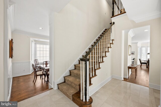 stairs featuring ornamental molding, arched walkways, and recessed lighting