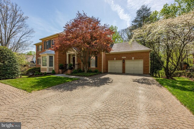 view of front of property featuring a garage, decorative driveway, a front yard, and brick siding