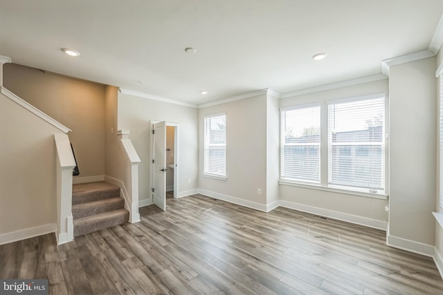 unfurnished living room with crown molding, recessed lighting, wood finished floors, and stairway