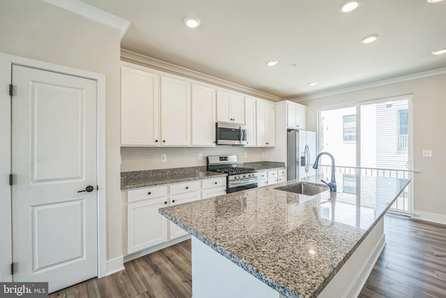 kitchen with crown molding, a kitchen island with sink, white cabinetry, dark wood finished floors, and stainless steel appliances
