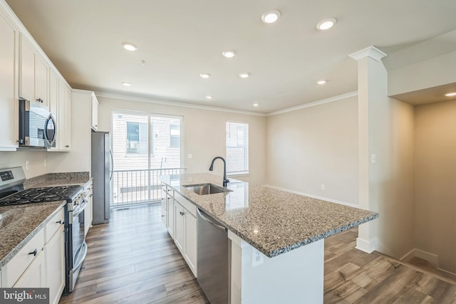 kitchen featuring a sink, appliances with stainless steel finishes, crown molding, and light wood finished floors