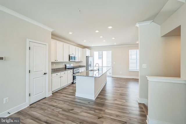 kitchen featuring a sink, baseboards, ornamental molding, and stainless steel appliances