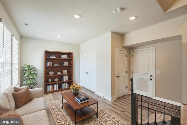 living area with recessed lighting, baseboards, light wood-type flooring, and visible vents