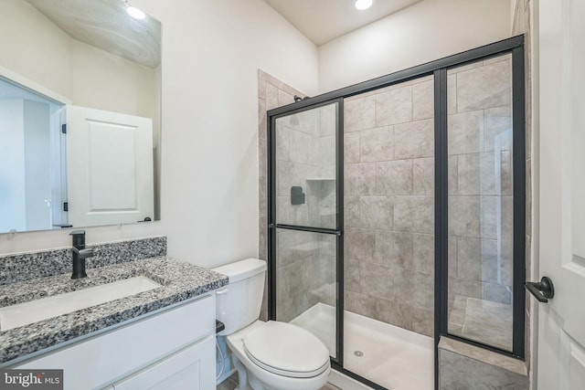 full bathroom with vanity, toilet, and a stall shower