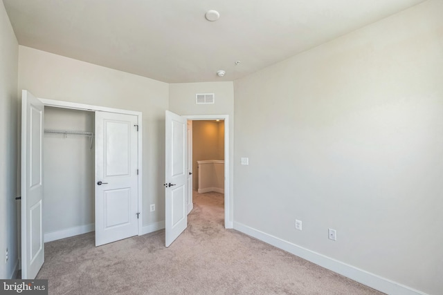 unfurnished bedroom featuring visible vents, baseboards, carpet floors, and a closet