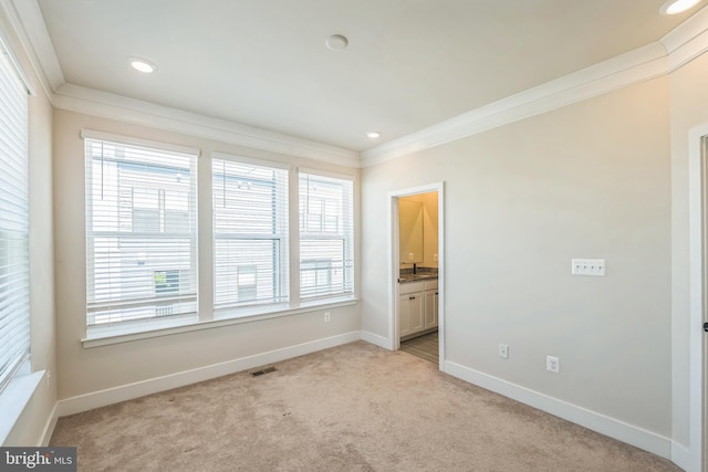 unfurnished bedroom with visible vents, ornamental molding, multiple windows, and light carpet