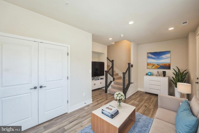 living room with visible vents, baseboards, stairway, recessed lighting, and light wood-style flooring