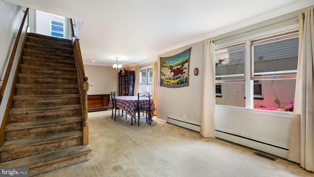 carpeted dining space with a baseboard heating unit, ornamental molding, an inviting chandelier, and stairway