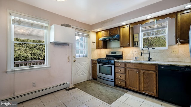 kitchen with black dishwasher, baseboard heating, stainless steel range with gas cooktop, under cabinet range hood, and a sink