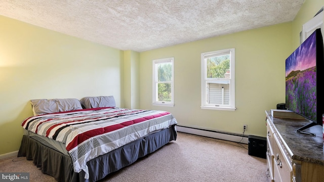 carpeted bedroom with baseboards, a textured ceiling, and baseboard heating
