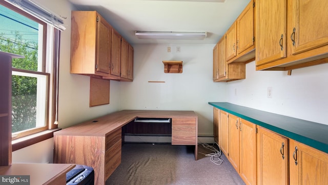 office area with dark carpet, a healthy amount of sunlight, and baseboard heating
