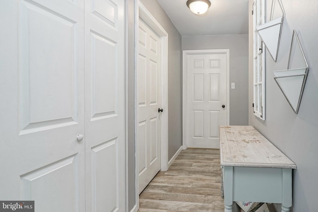hallway with light wood finished floors and baseboards