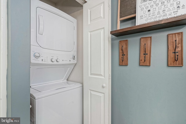 clothes washing area with stacked washing maching and dryer and laundry area