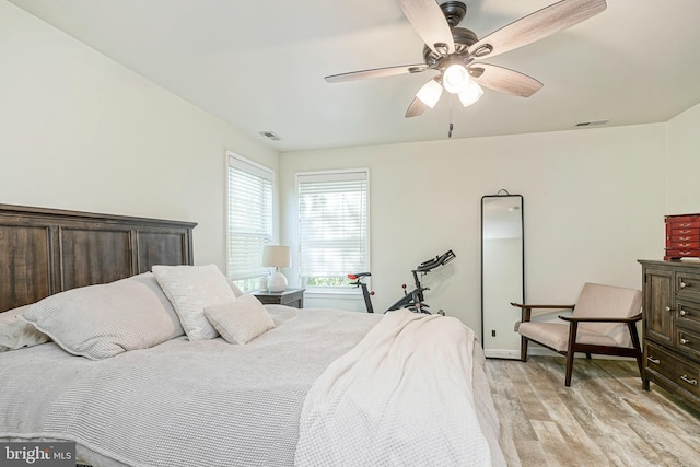 bedroom with a ceiling fan, visible vents, baseboards, and light wood-style floors