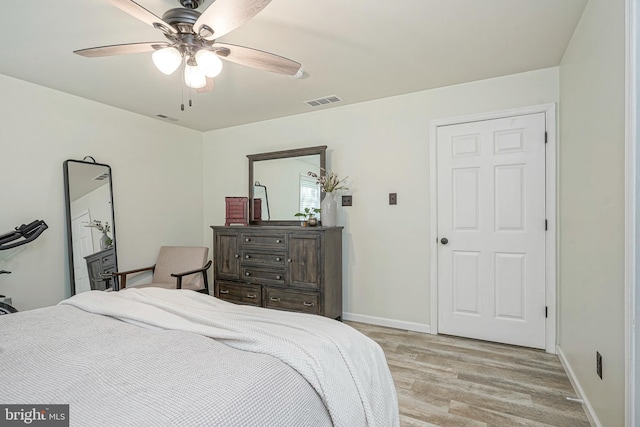 bedroom with baseboards, visible vents, light wood-type flooring, and ceiling fan