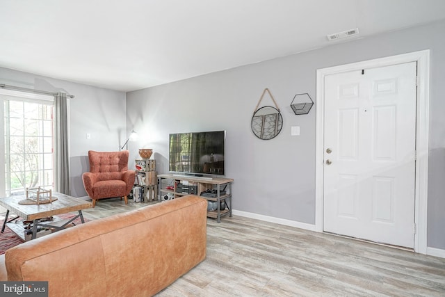 living area featuring baseboards, visible vents, and light wood-style flooring