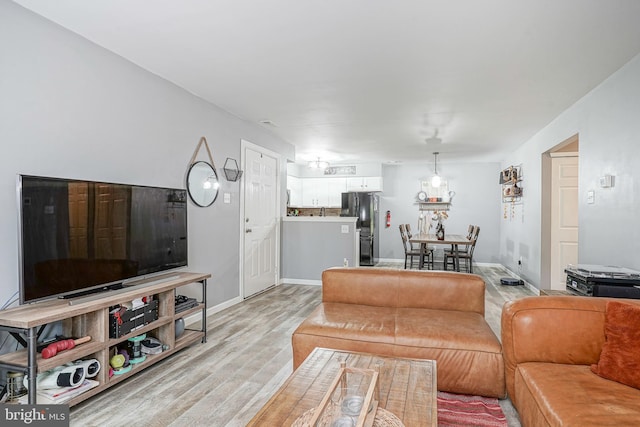 living room featuring light wood-style floors and baseboards