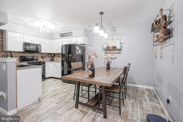 dining area with light wood finished floors, an inviting chandelier, and baseboards