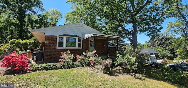 bungalow-style home with brick siding and a front yard