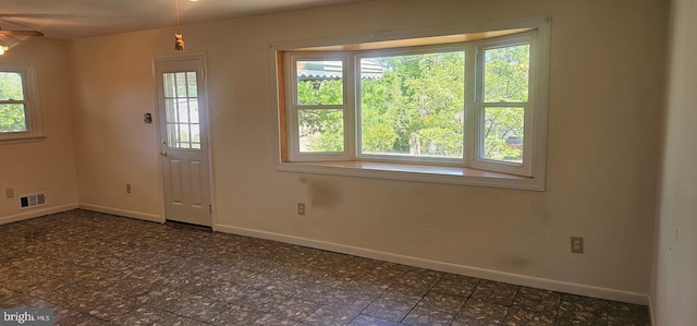doorway to outside featuring a wealth of natural light, visible vents, and baseboards