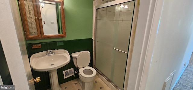 full bathroom with visible vents, toilet, a stall shower, and a sink