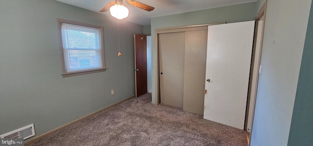 unfurnished bedroom with a closet, visible vents, ceiling fan, and carpet floors