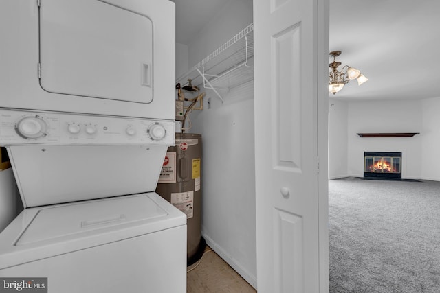 6703 Rapid Water Way Unit 203, Glen Burnie, MD 21060 - clothes washing area with laundry area, a glass covered fireplace, stacked washer / dryer, baseboards, and electric water heater