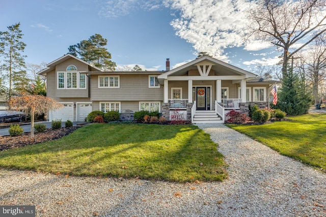 view of front of home with covered porch, a chimney, a front lawn, and a garage